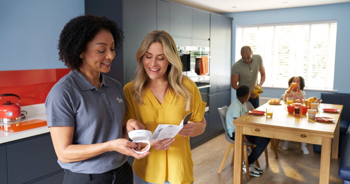 Heat Pump Week 6 CBH A female heat pump installer talking to a family about their new heating controls